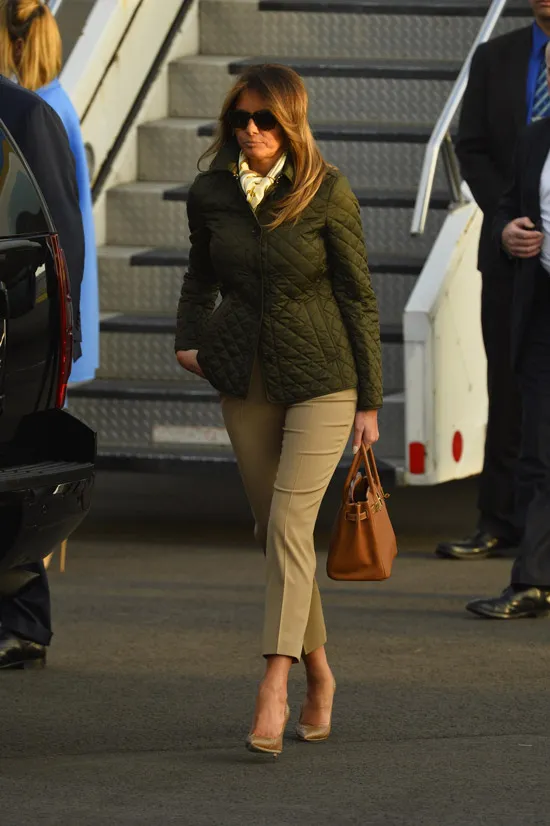 Мелания Трамп в стеганой куртке и серых брюках