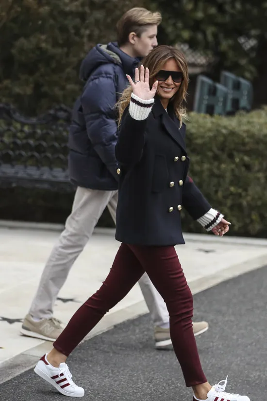 Мелания Трамп в бордовых джинсах и коротком пальто