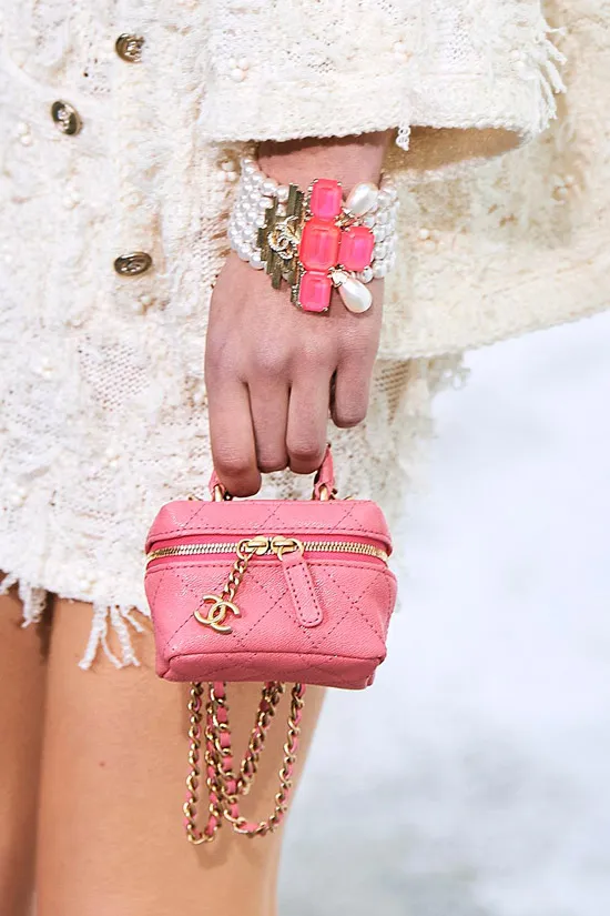 Модель с розовой мини сумочкой на молнии с золотыми цепочками от chanel