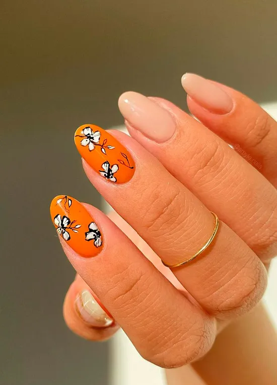 Оранжевый маникюр с черно белыми цветами на овальных ногтях