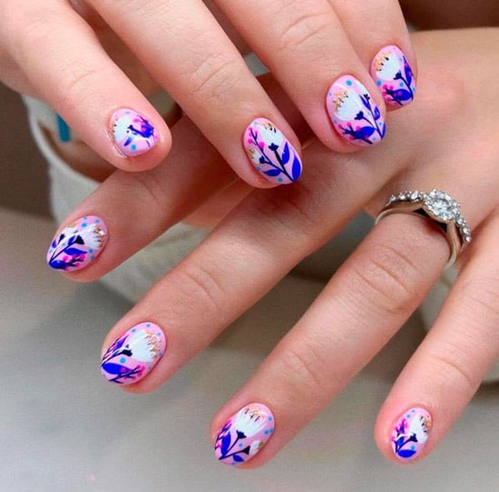 Розовый маникюр с белыми цветами и синими листьями на коротких овальных ногтях