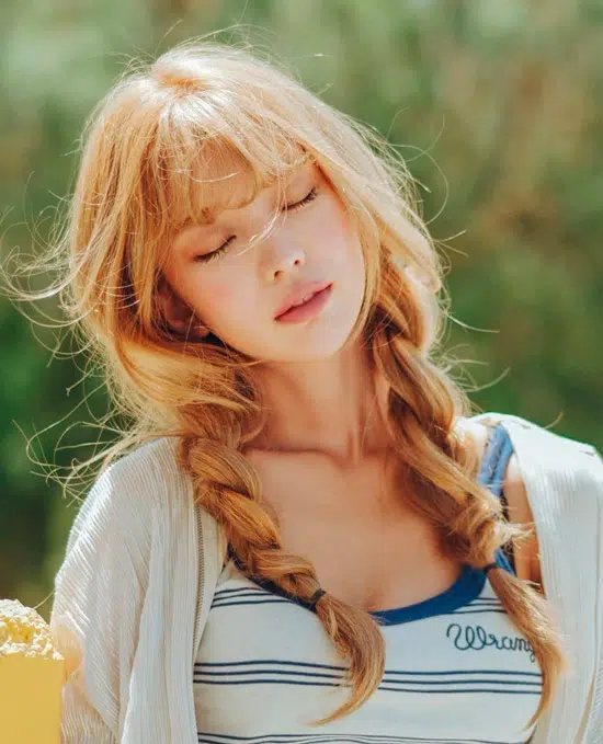 Девушка со светлыми рыжими волосами заплетенные в свободные косички и челка