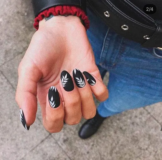 черный матовый маникюр с белыми листьями на овальных ногтях