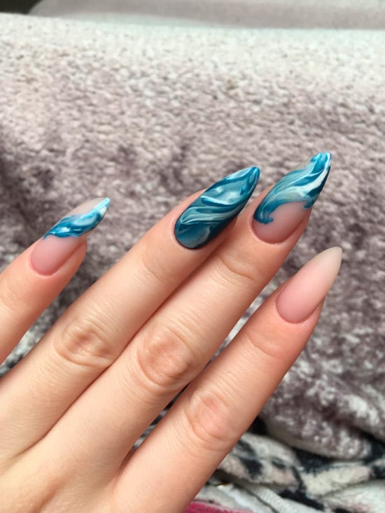 Синий мраморный маникюр с волнами на длинных острых ногтях