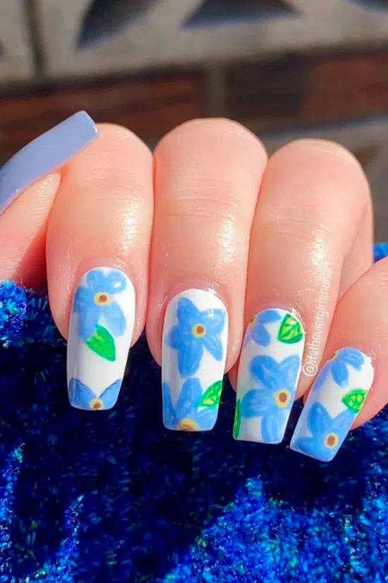 Белый маникюр с голубыми цветами на длинных ногтях