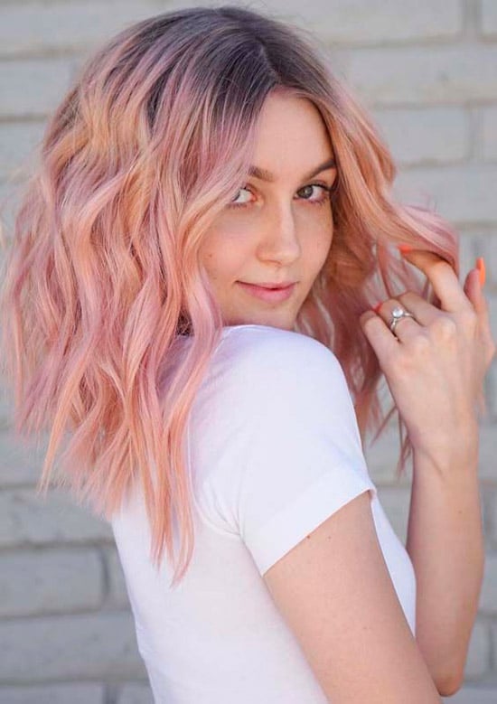 Девушка с нежно-розовыми волосами с пробором по середине на волосах средней длины