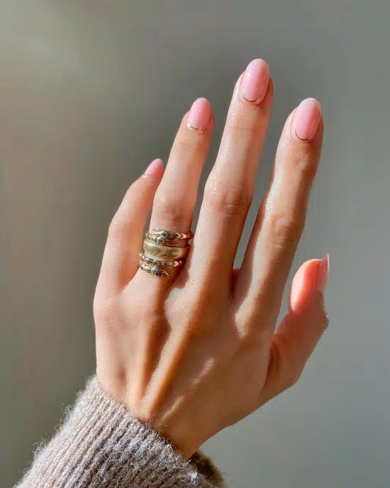 Нежный розовый маникюр с золотой полосой на овальных ногтях средней длины