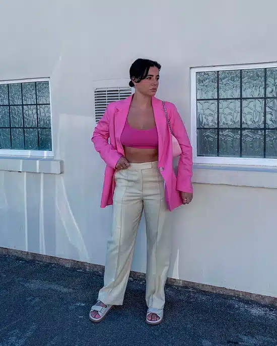 Девушка в бежевых офисных брюках, розовое бюстье и жакет