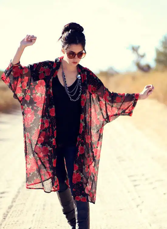 Девушка в темных джинсах, черный топ и прозрачное кимоно с красными цветами