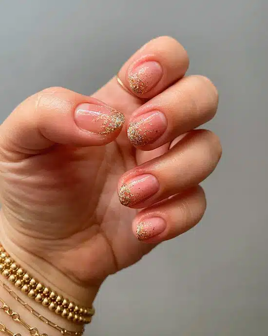 Естественный маникюр с золотыми блестками на овальных ногтях
