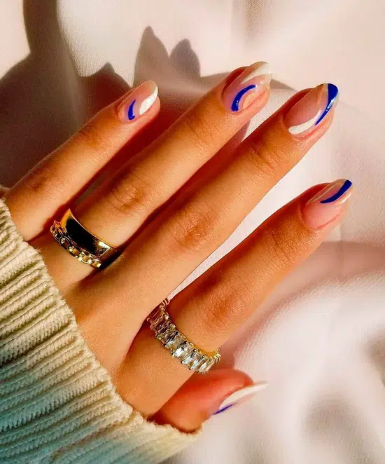 Абстрактный маникюр с белыми и синими линиями на овальных ногтях