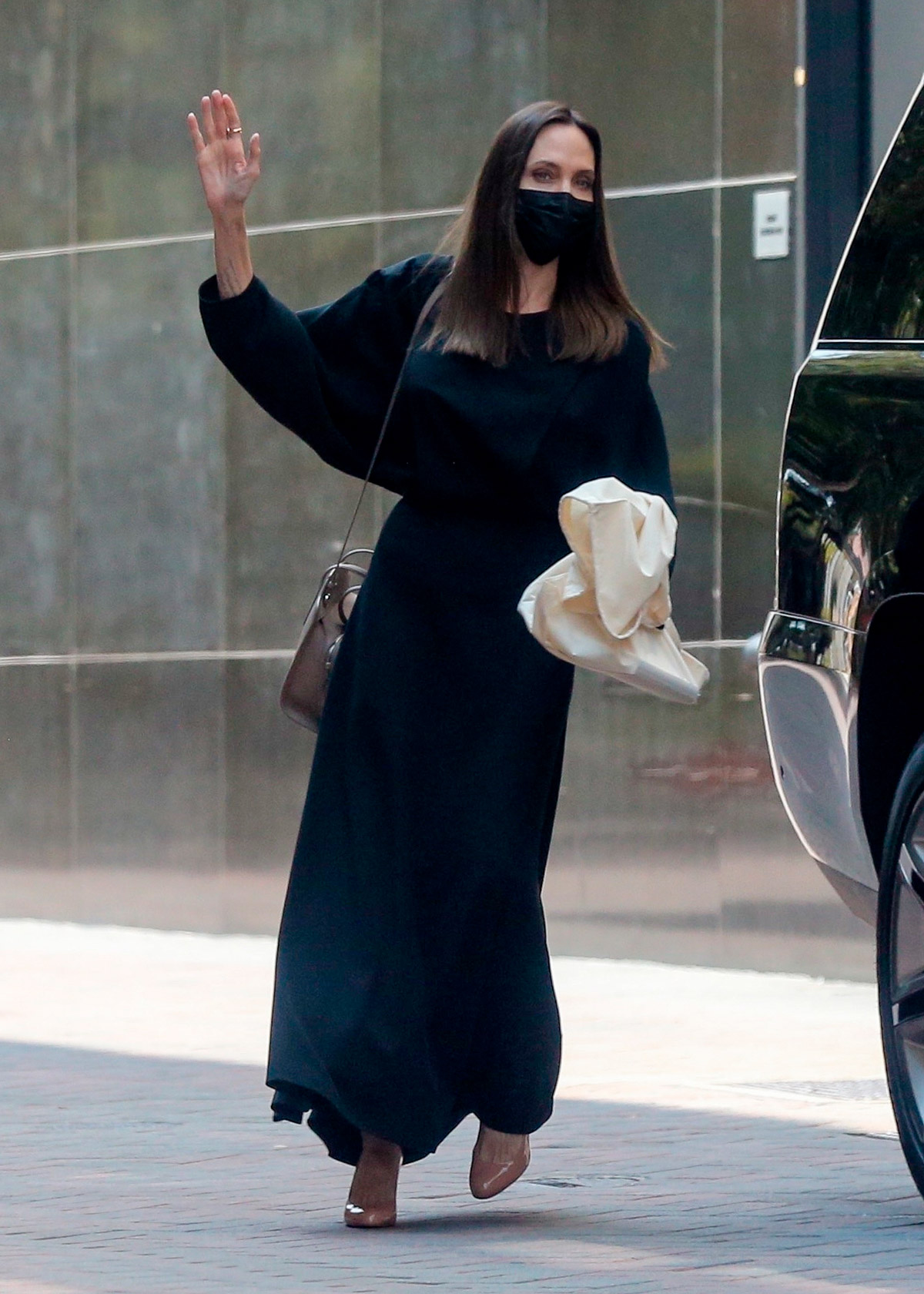 Анджелина Джоли в черном платье машет рукой