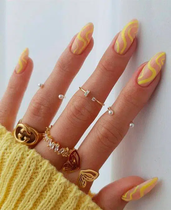 Натуральный маникюр с желтыми волнистыми линиями на длинных миндальных ногтях
