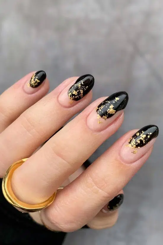 Черный маникюр с золотой фольгой на овальных ногтях
