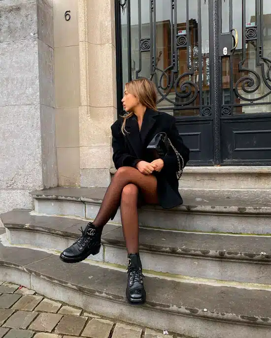 Девушка в черном пальто и ботинках на шнуровке