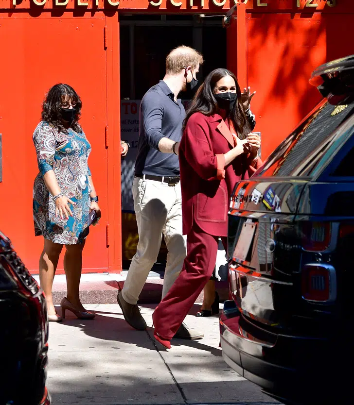 Меган Маркл в бордовом пальто и широких брюках