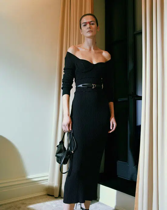 Модель в черном облегающем платье с открытыми плечами и ремнем на талии от Altuzarra