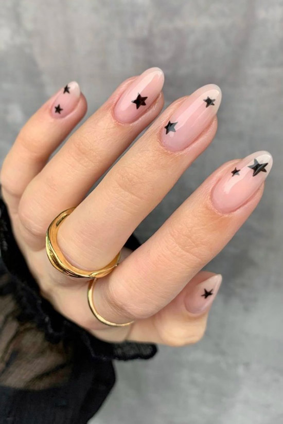 Маникюр с черными звездами на овальных ногтях
