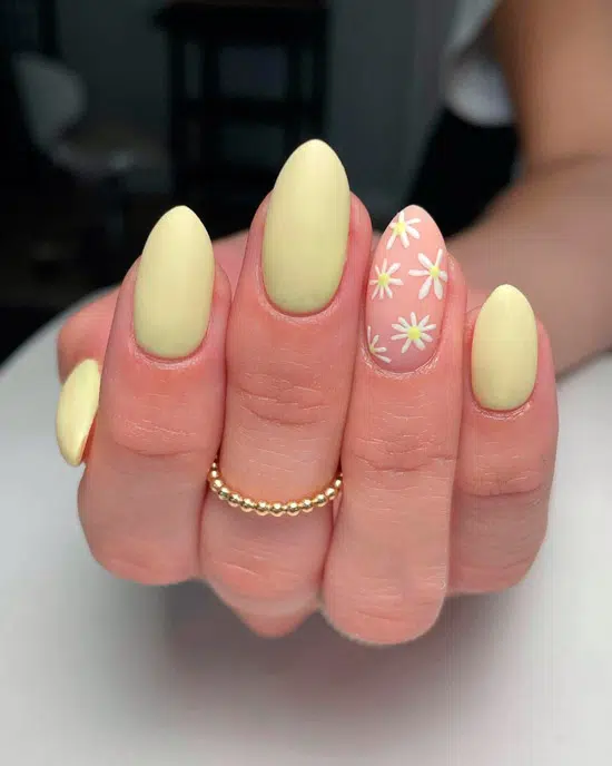 Желтый маникюр с цветочным принтом на миндальных ногтях