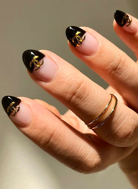 Черный френч с золотым логотипом на овальных ногтях средней длины