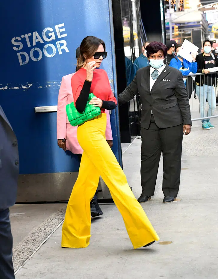 Виктория Бекхэм в желтых брюках и зеленой сумкой