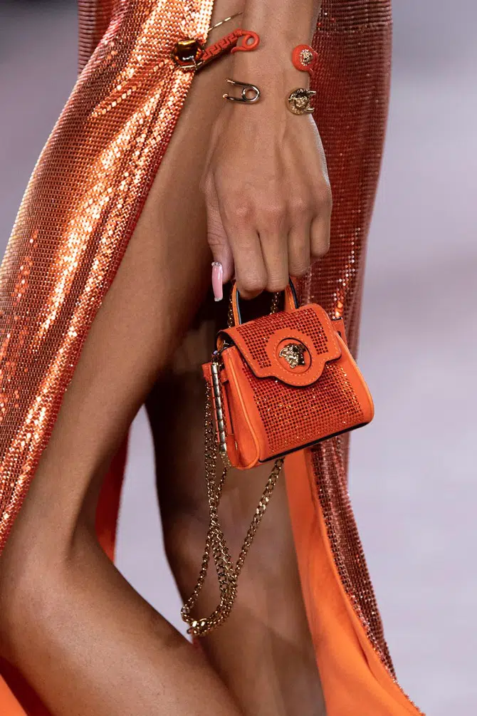 Модель с оранжевой мини сумочкой со стразами