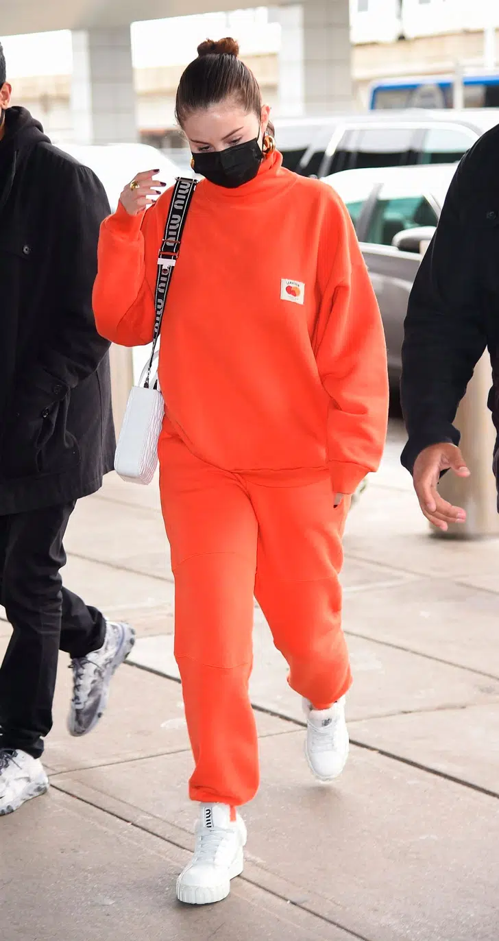 Селена Гомес в оранжевом костюме и кроссовках с мехом
