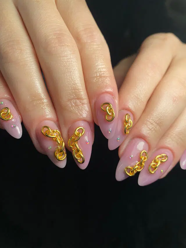 Прозрачный розовый маникюр с золотыми цепями на острых ногтях