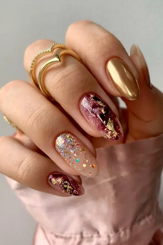 Красивый золотой маникюр с блестками на овальных ухоженных ногтях