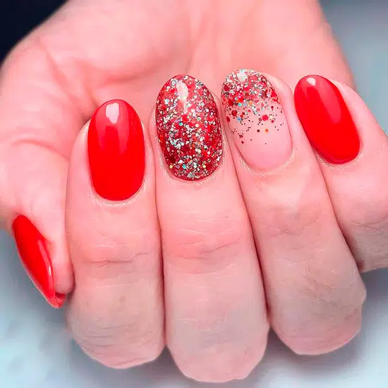 Красный маникюр с блестками на овальных натуральных ногтях