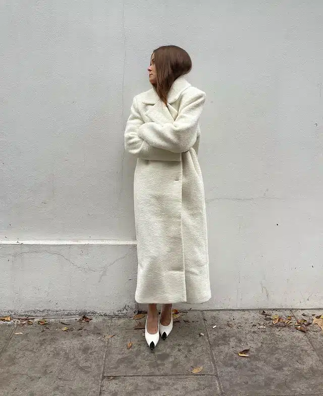 Девушка в белом плюшевом пальто и туфлях с черным носком от Saint Laurent