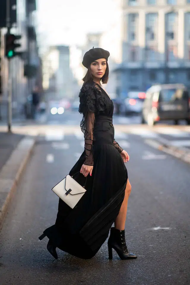 Девушка в черной длинной юбке с вырезом, блузке с рюшами и черном берете