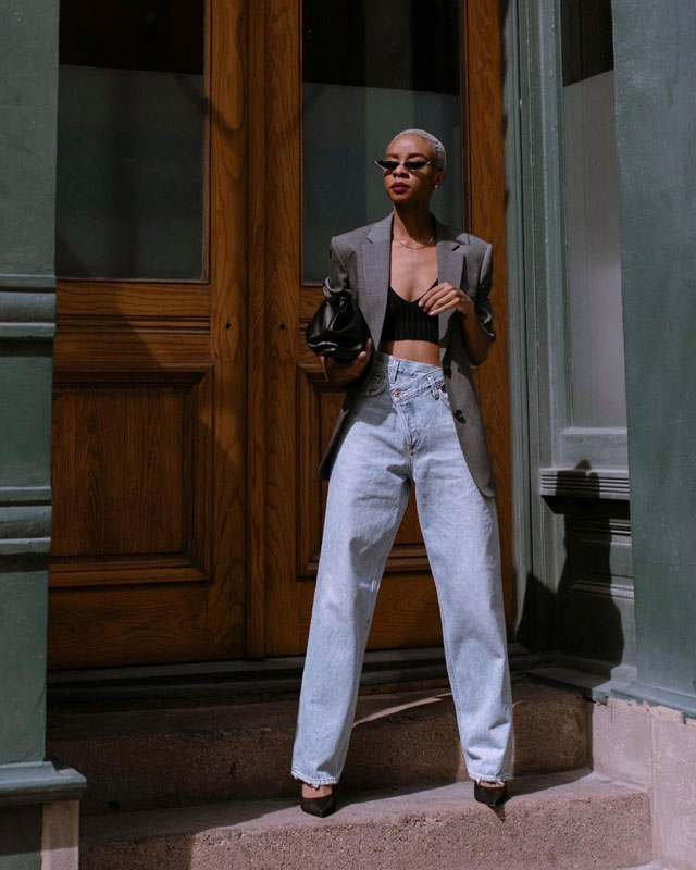 Девушка в прямых джинсах с асимметричной талией и сером жакете