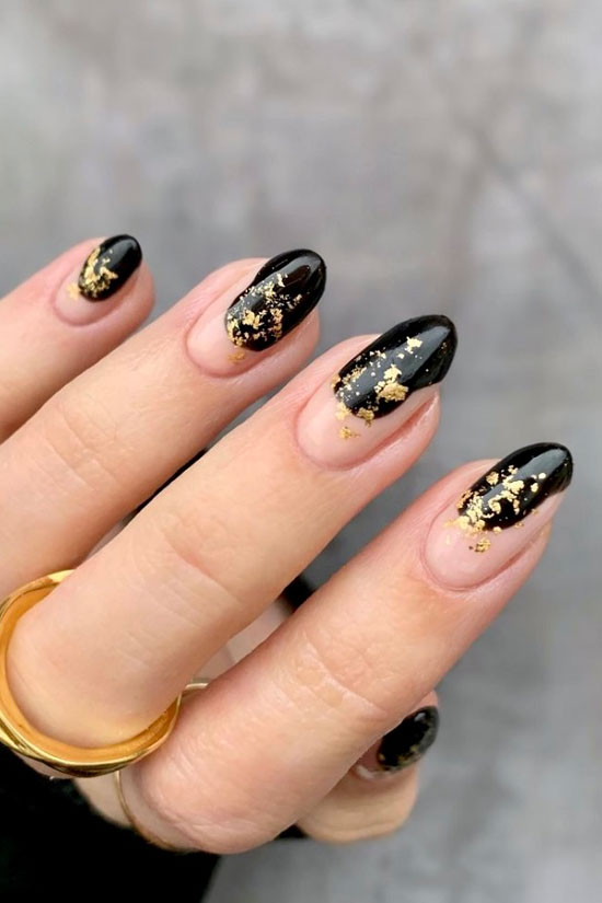 Черный глянцевый маникюр с золотыми хлопьями на овальных ногтях средней длины