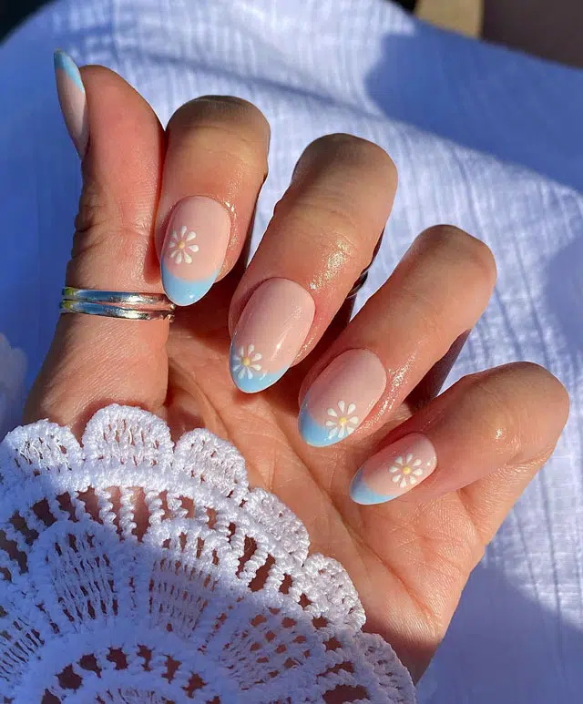 Голубой френч с белыми цветами на овальных ногтях средней длины