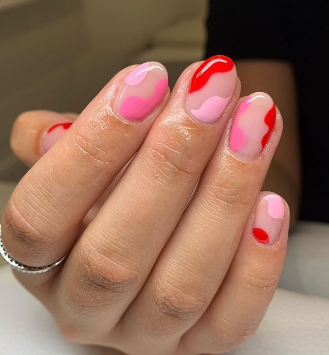 Красные и розовые завитки на коротких овальных ногтях