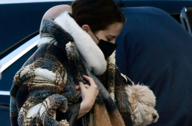 Селена Гомес в уютном клетчатом пальто в одной руке несет свою милую собачку, а в другой сумку Prada
