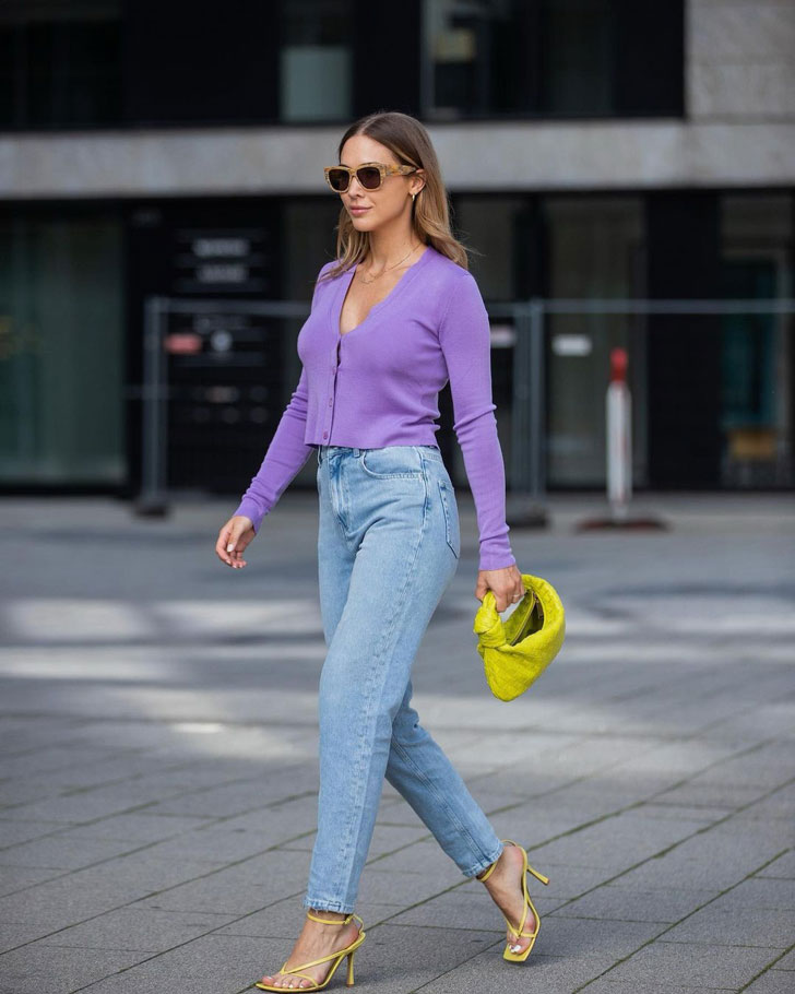 Девушка в прямых джинсах, тонком фиолетовом кардигане и желтых босоножках