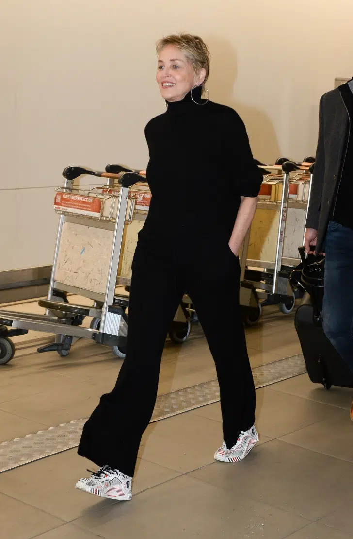 Шэрон Стоун в черном свитере, брюках и заметных кроссовках