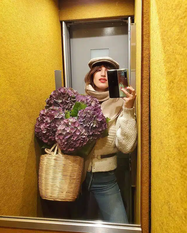 Жанна Дамас в простых джинсах, уютном свитере и кепке
