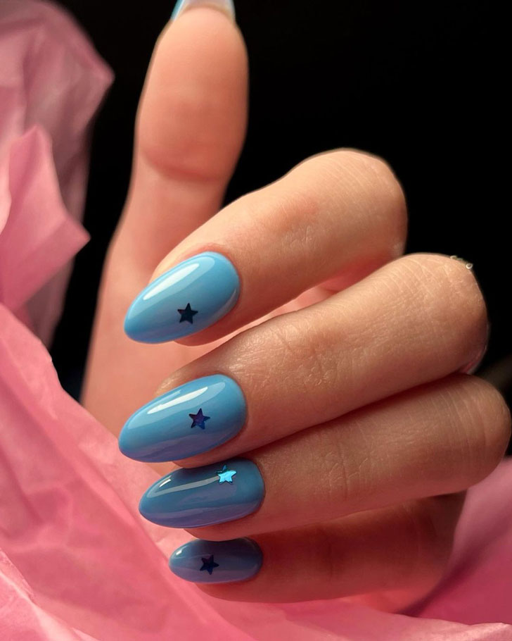 Голубой маникюр со звездами на миндальных ногтях средней длины