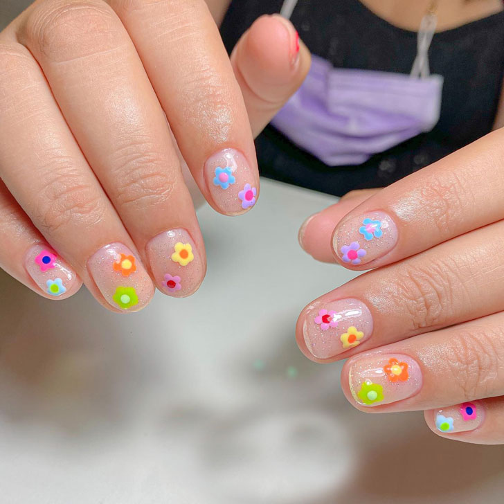 Маникюр с весенними разноцветными цветами на коротких овальных ногтях