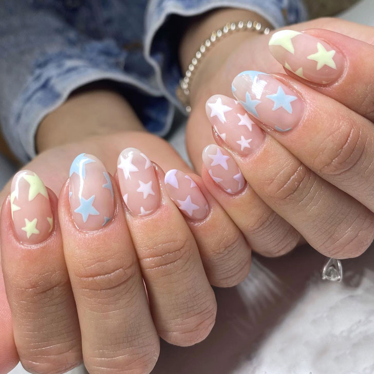 Натуральные ногти с пастельными звездами на овальных ногтях