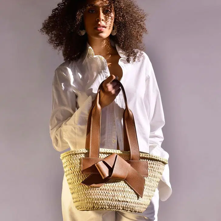 Девушка с модной сумкой из рафии с кожаными лямками