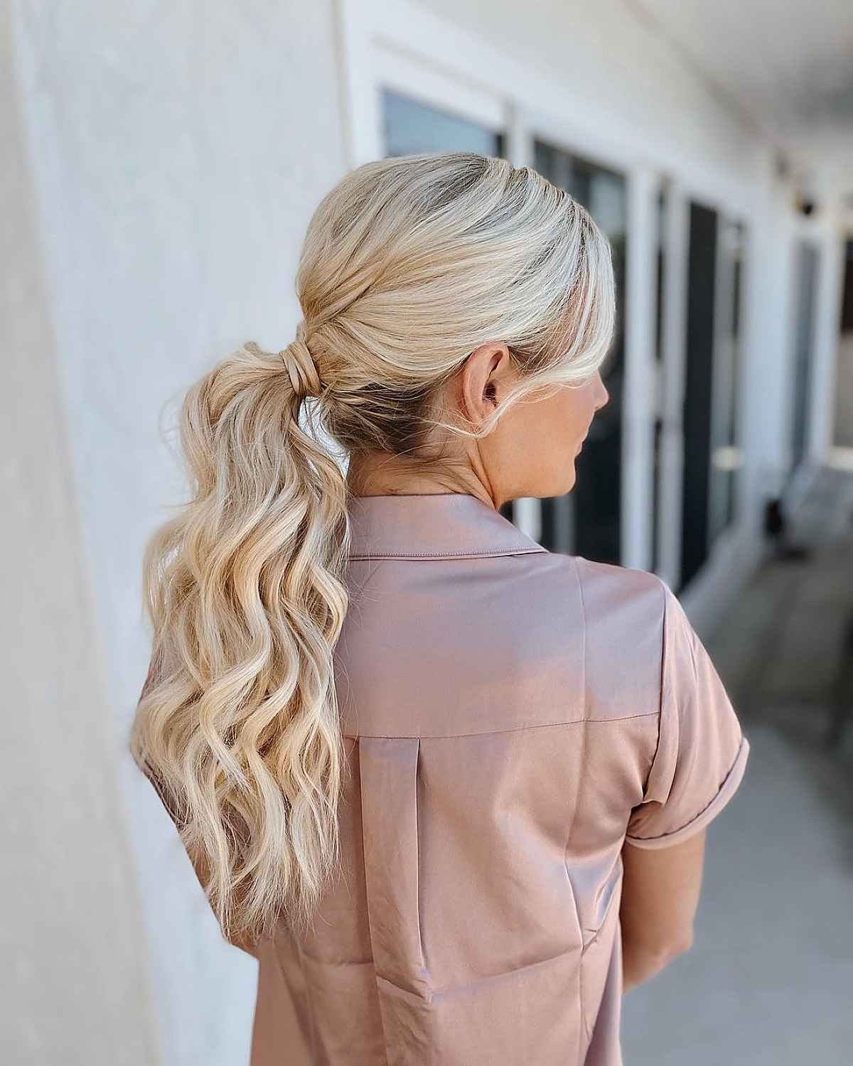 Девушка с текстурированным хвостом с волнами на длинных светлых волосах