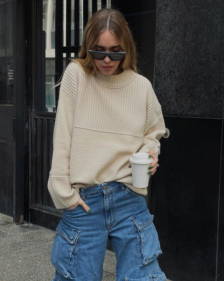 Девушка в джинсовых брюках карго и бежевом свитере