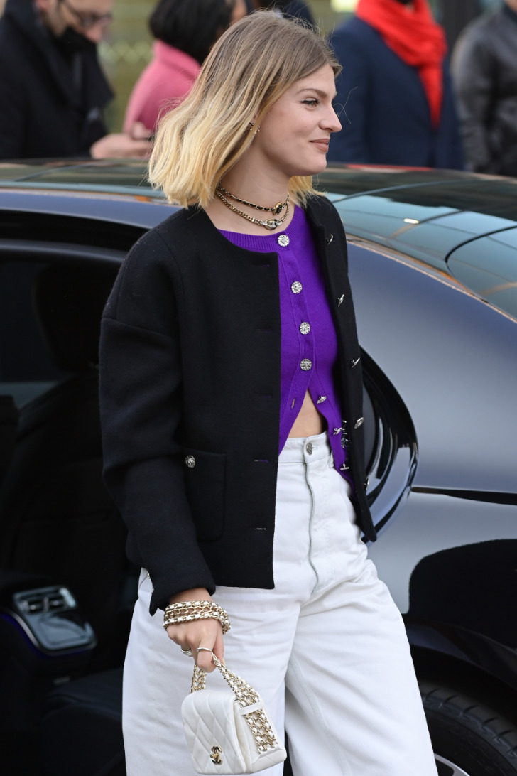Девушка из Парижа в широких джинсах и фиолетовом кардигане