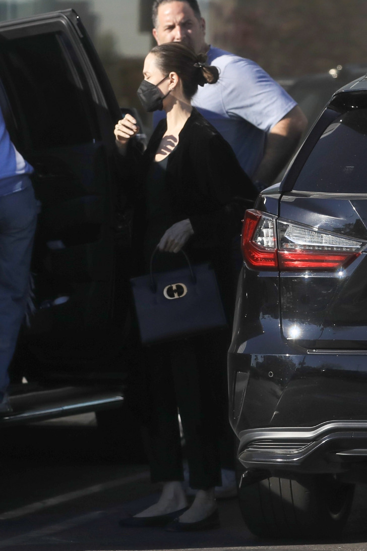 Анджелина Джоли в классических брюках и кардигане