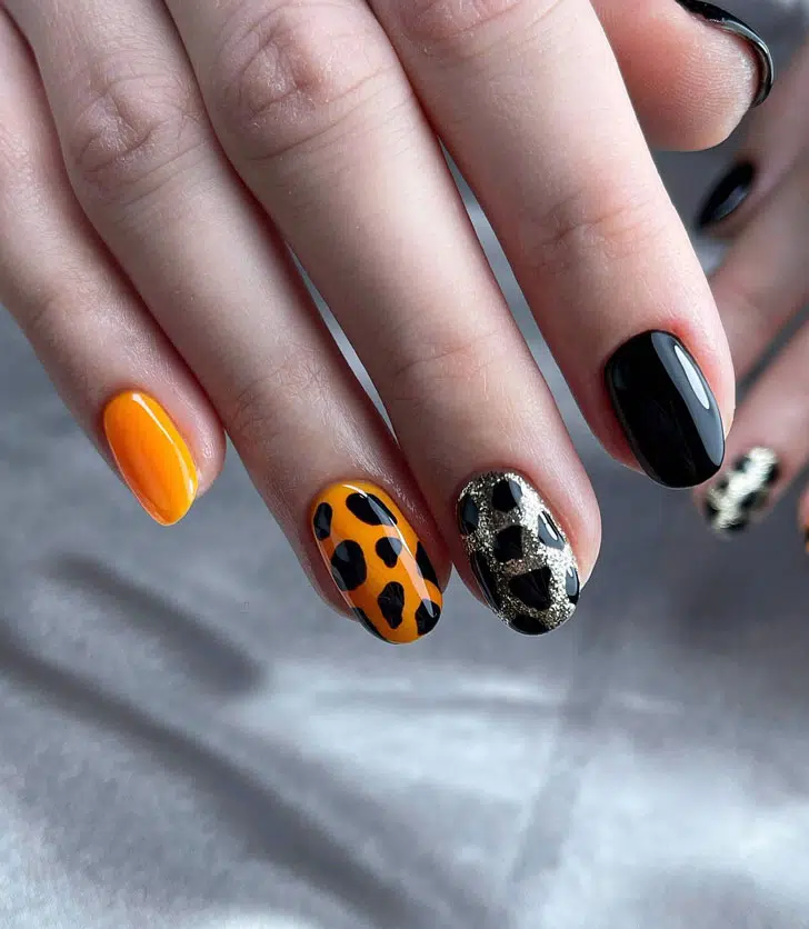 Черно оранжевый маникюр с животным принтом на овальных ногтях
