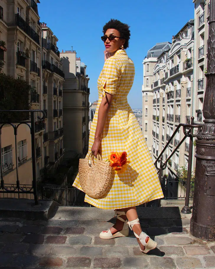 Француженка в желтом платье рубашка в клетку и соломенной сумкой